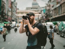 shallow focus photography of man using a DSLR camera