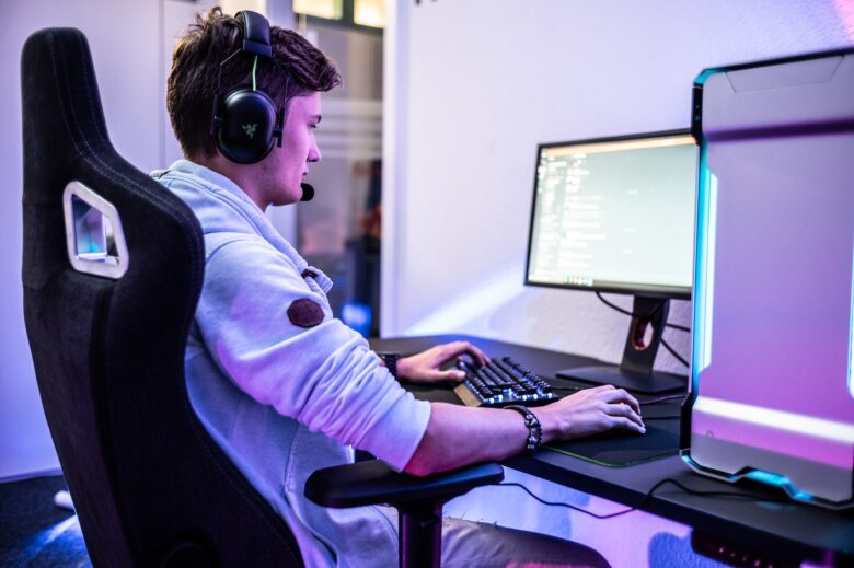 a young man wearing headphones sitting in front of a computer