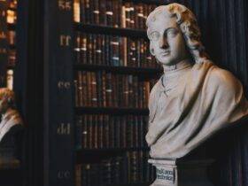 man wearing robe bust figurine near black wall