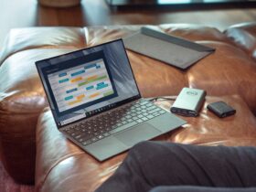 black and gray laptop computer on brown leather couch