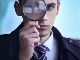 man in black suit holding magnifying glass