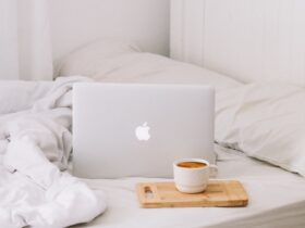 MacBook beside teacup with latte