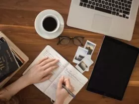 person holding ballpoint pen writing on notebook