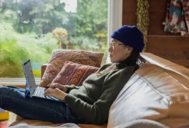 a person sitting at a table using a laptop