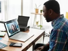 man in blue and white plaid dress shirt using macbook pro