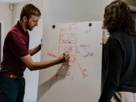 man drawing on dry-erase board