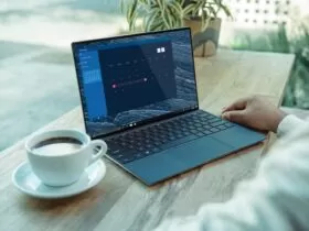 person using black laptop computer on brown wooden table