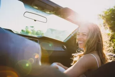 smiling woman sitting inside the vehicle at daytime