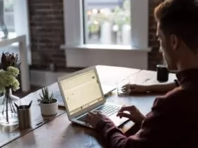 man operating laptop on top of table