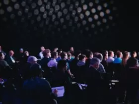 crowd of people sitting on chairs inside room