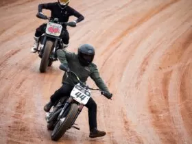 two men riding motocross on road