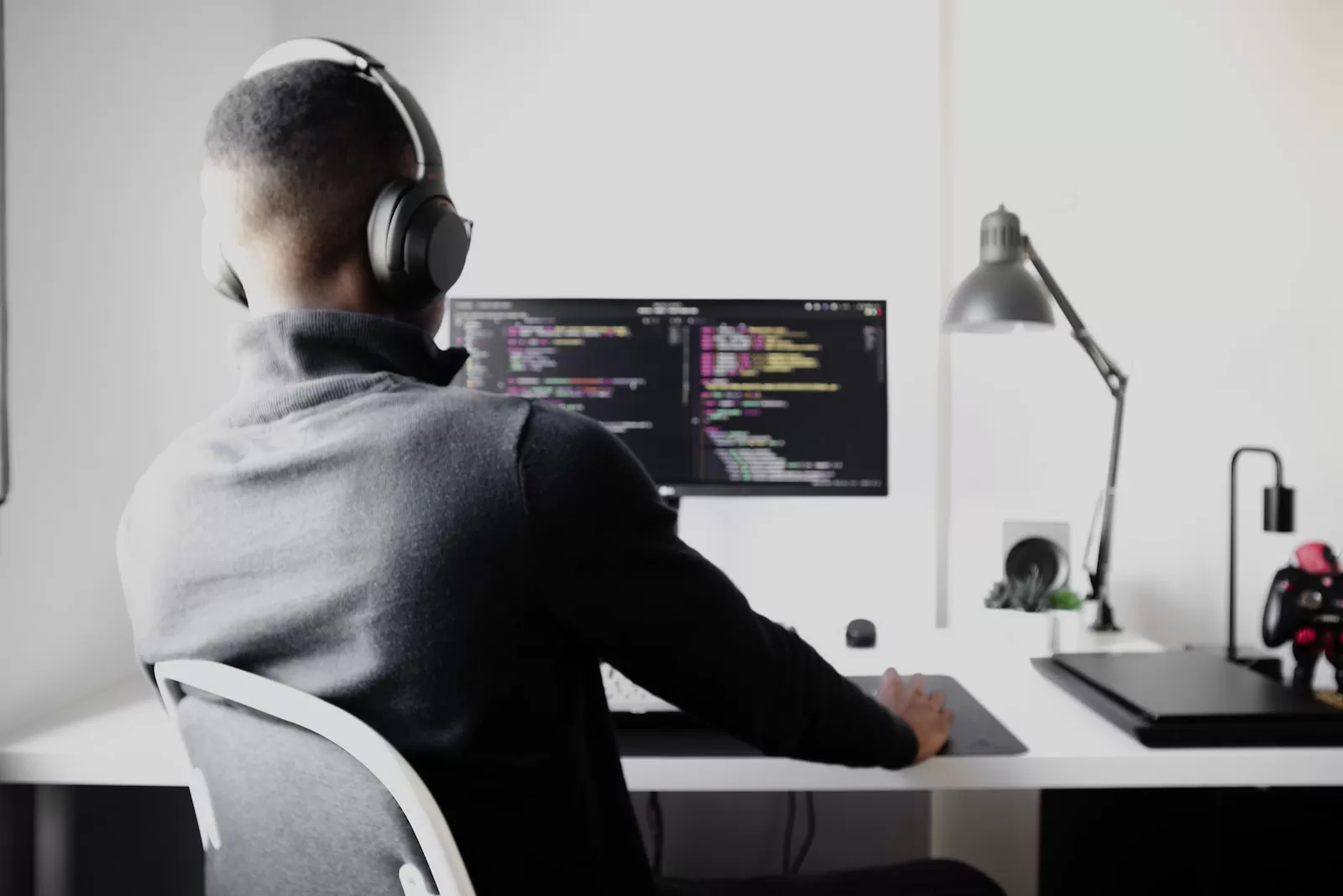 man in black long sleeve shirt wearing black headphones sitting on chair