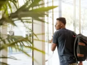 man holding glass door