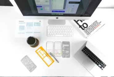 silver MacBook Air on table near iMac