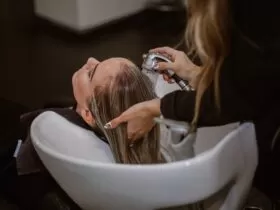 a woman getting her hair cut by a hair stylist