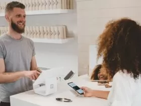 man in grey crew-neck t-shirt smiling to woman on counter