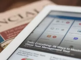 white tablet computer on top of newspaper