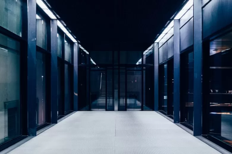 a long hallway with glass doors leading to another room