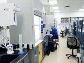 man in blue scrub suit standing near white and black office rolling chair