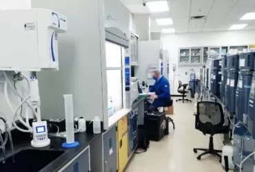 man in blue scrub suit standing near white and black office rolling chair