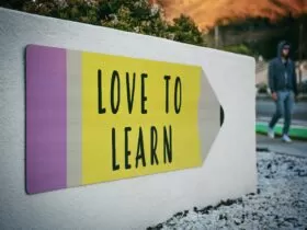 love to learn pencil signage on wall near walking man