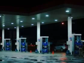 person taking a photo of blue and white gasoline station