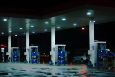 person taking a photo of blue and white gasoline station