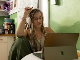 a woman with dreadlocks sitting in front of a laptop computer